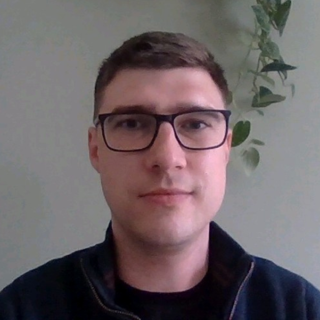 This is an image of a woman working at a desk with two monitors in front of her.