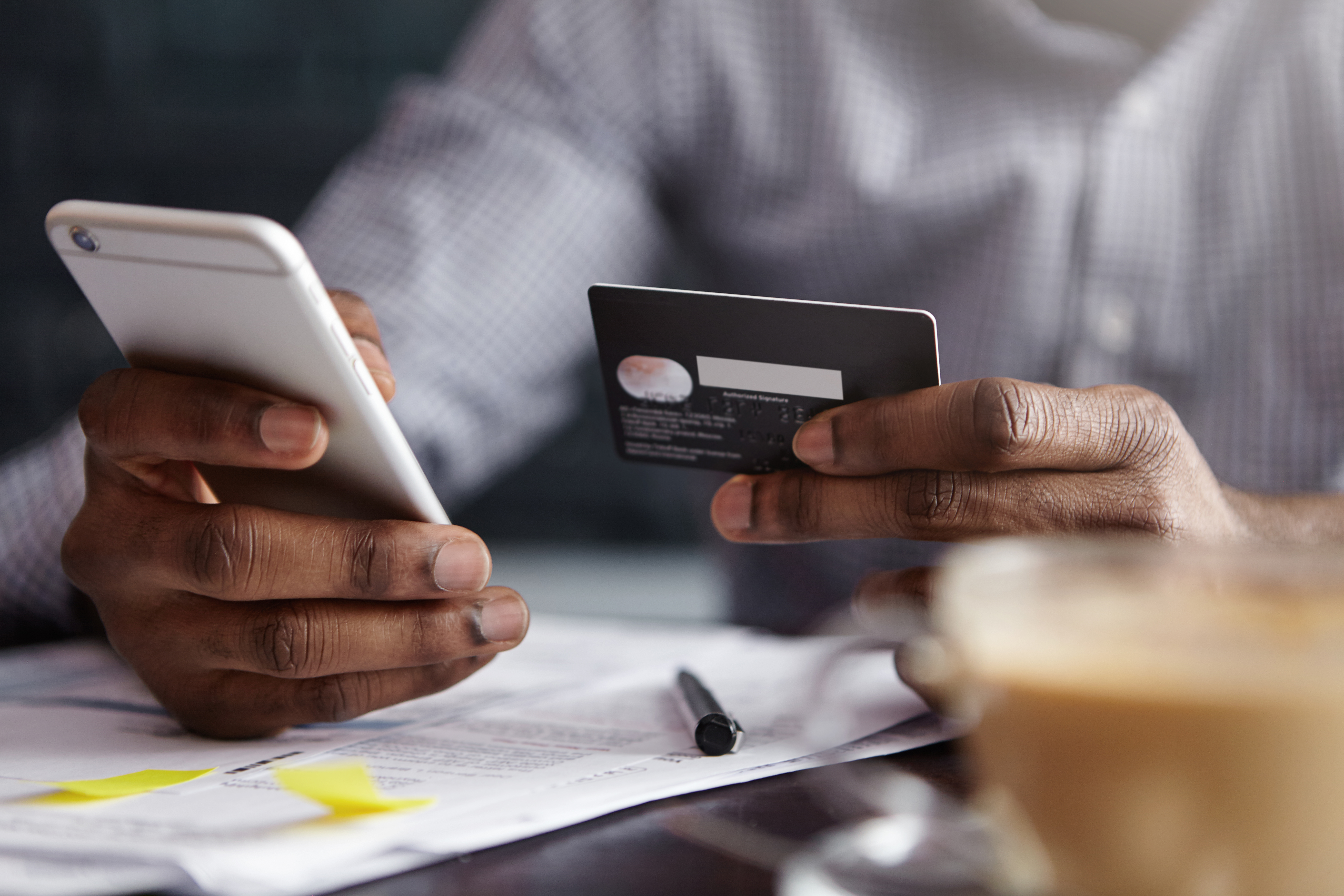 This is an image of a man making a payment over the phone with his credit card