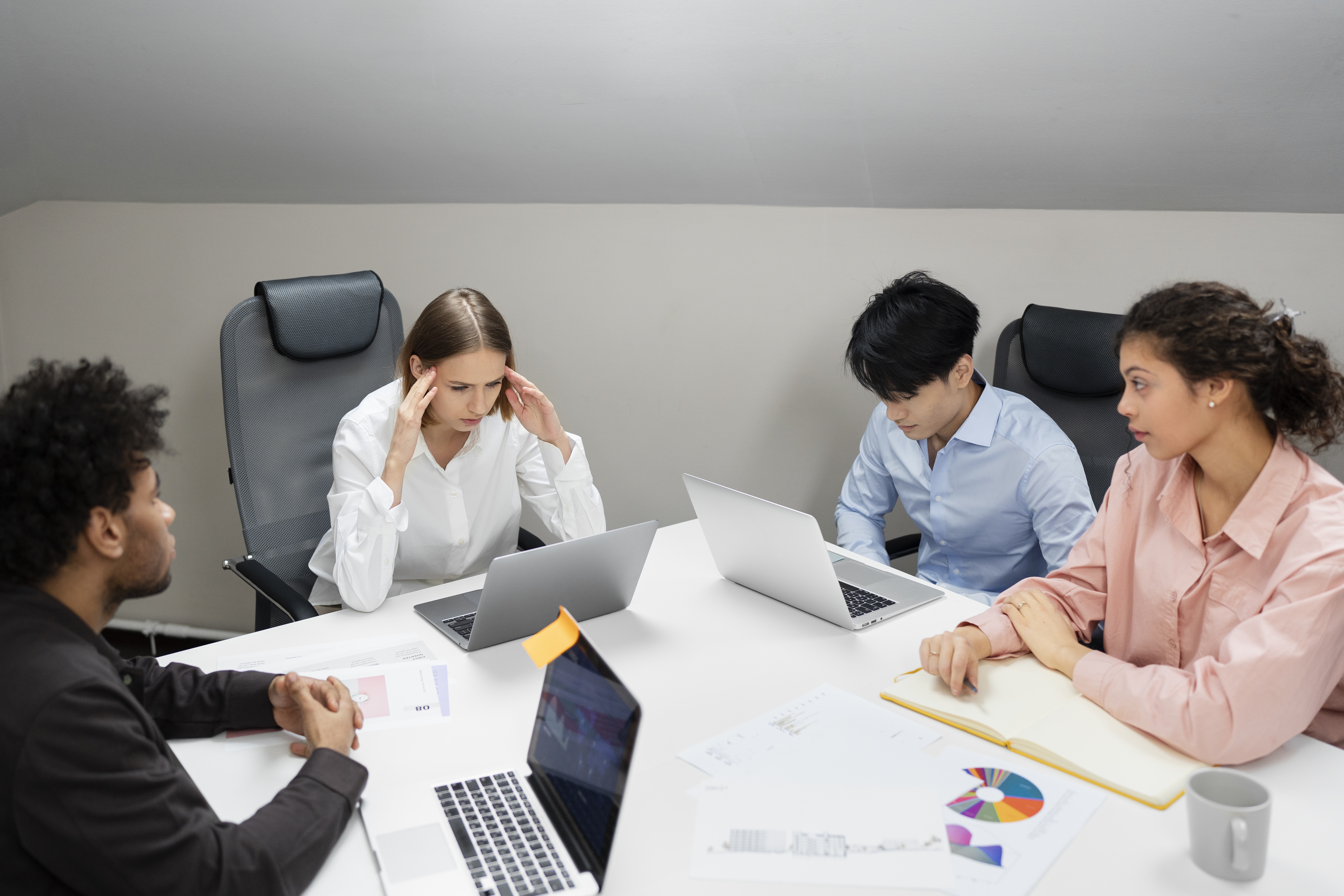 This is an image of people working at a boardroom desk. 